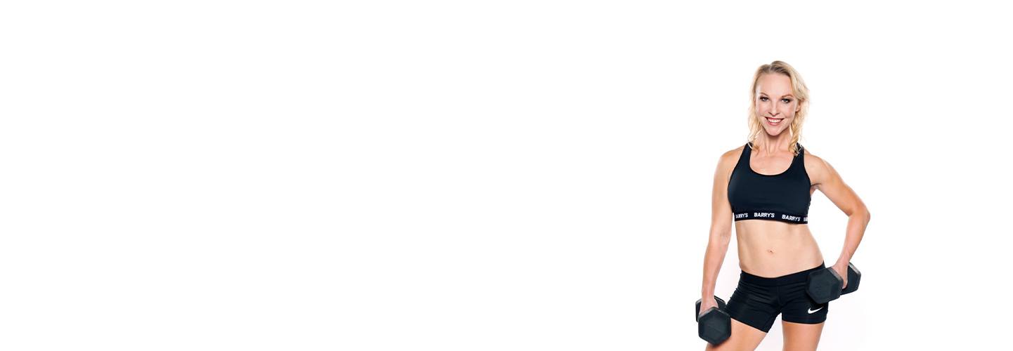 Barrys instruktör Brooke Sheely i svart sport-bh poserar med hantel