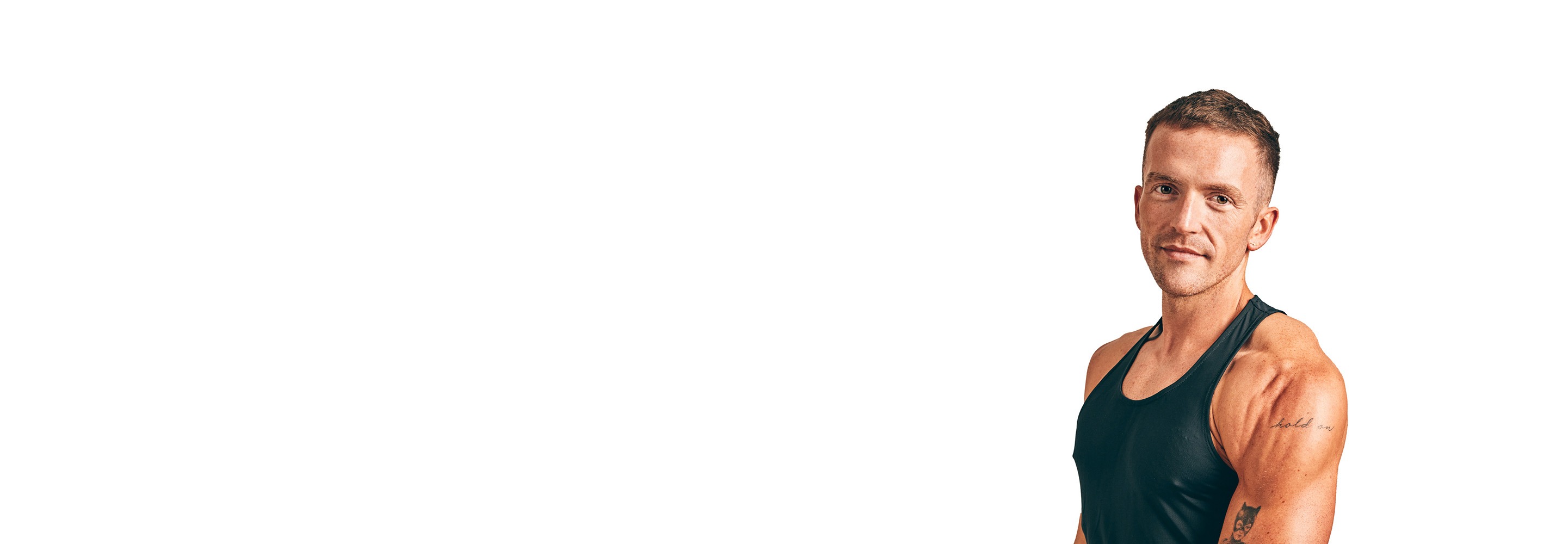 Barrys instruktör iklädd en svart topp står självsäkert och ler mot en vit bakgrund