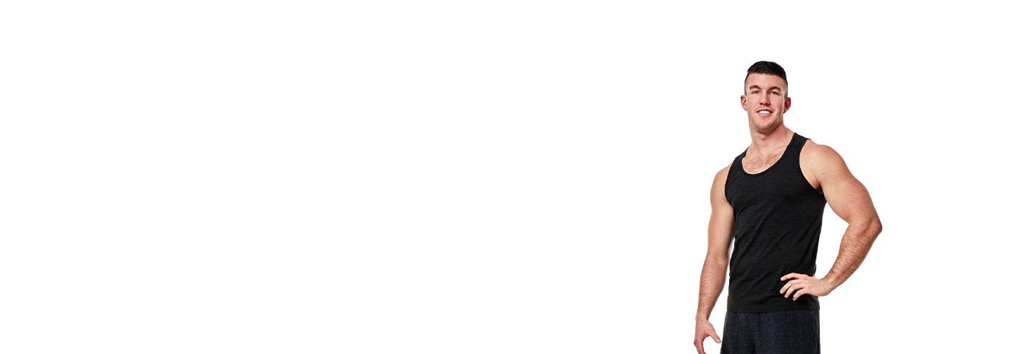 Barry's Bootcamp instructor Connor Miller in black tank top smiling with hand on hip on white background