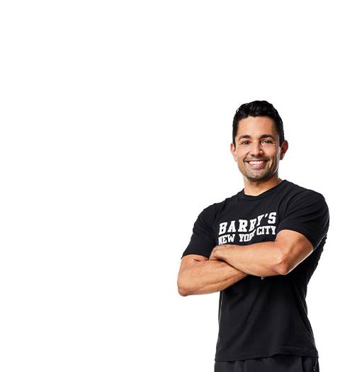 Instructor Harley Rodriguez in a Black Barry's T shirt with arms folded