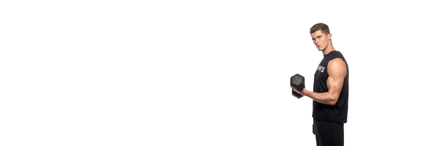 Barry's Bootcamp instructor Harry Sellers doing a bicep curl against a white background.