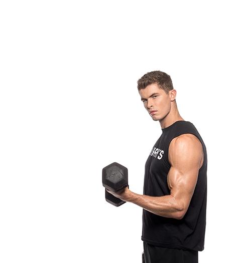 Barry's Bootcamp instructor Harry Sellers doing a bicep curl against a white background.