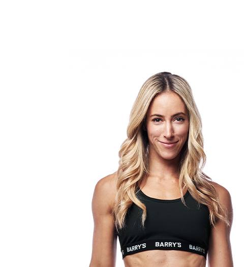 Barry's Bootcamp instructor Hayley Steinberg wearing a black bra against a white background.