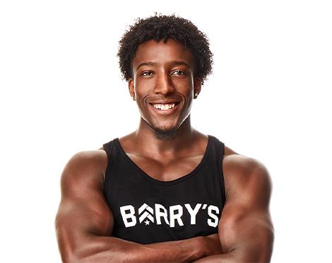 Headshot of Barry's Bootcamp instructor Joseph Allen wearing a black tank top with a Barry's logo on it against a white background.