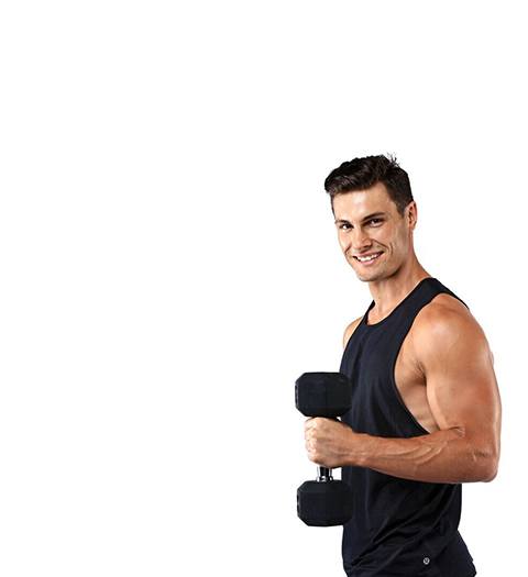 Barry's Bootcamp instructor Joe Nicastro in black tank top smiling while holding dumbbell on white background