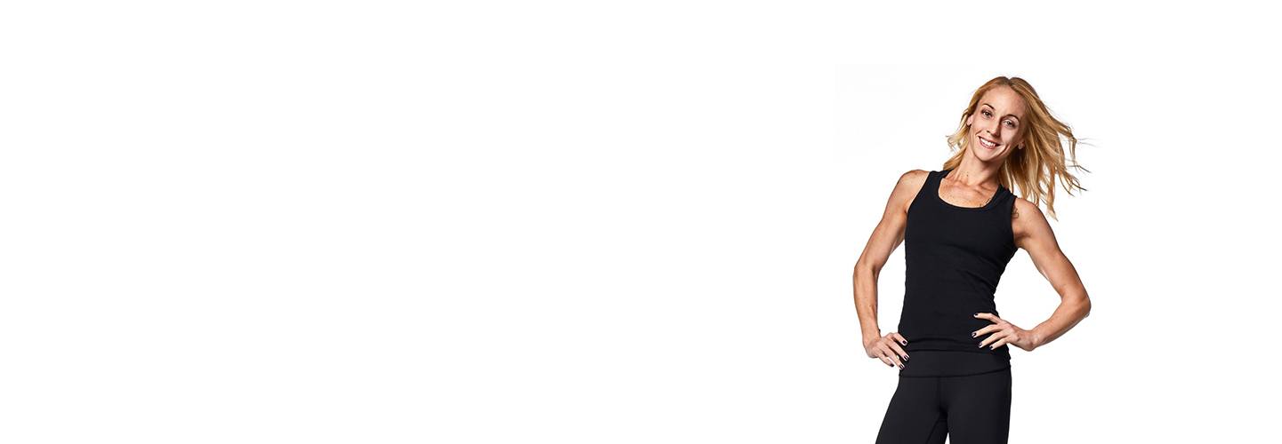 Barry's Bootcamp instructor Kelly Whittaker in black tank. Both hands on hip.