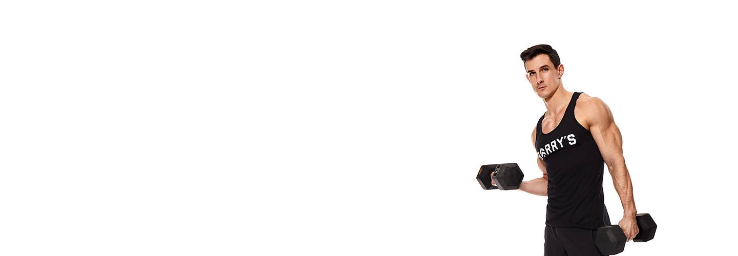 Instruktör Michael Pugliese i svart Barry's Bootcamp linne som håller hantlar på vit bakgrund