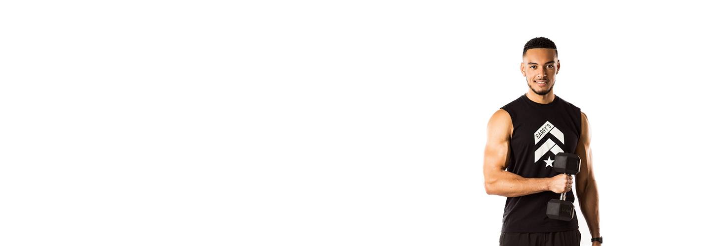 Barry's Instructor Miles Casey wearing black tank posing with dumbbell