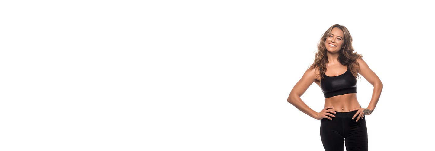 Barry's Bootcamp instructor Sarah Robinson wearing a black sports bra with her hands on her hips.