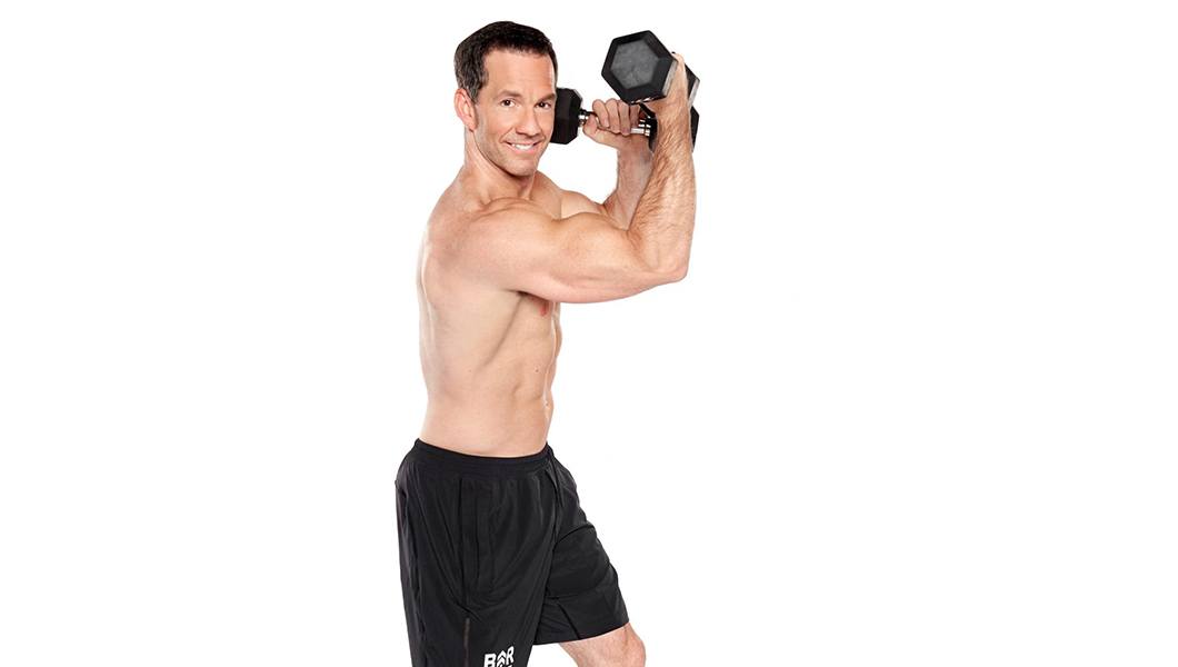 Barrys instructor Scott Haddock shirtless posing with dumbbells