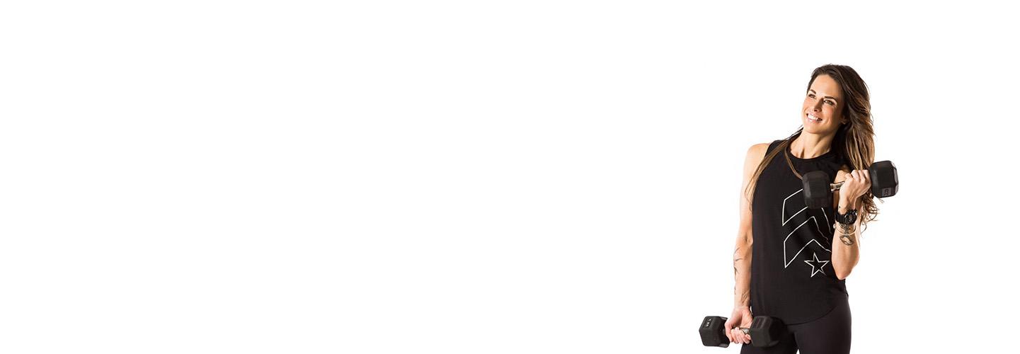 barrys instruktör Tee Zitzewitz bär svart tank poserar med hantlar