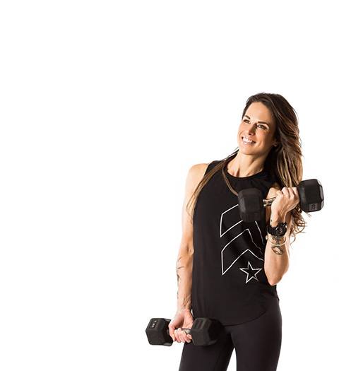 barrys instruktör Tee Zitzewitz bär svart tank poserar med hantlar