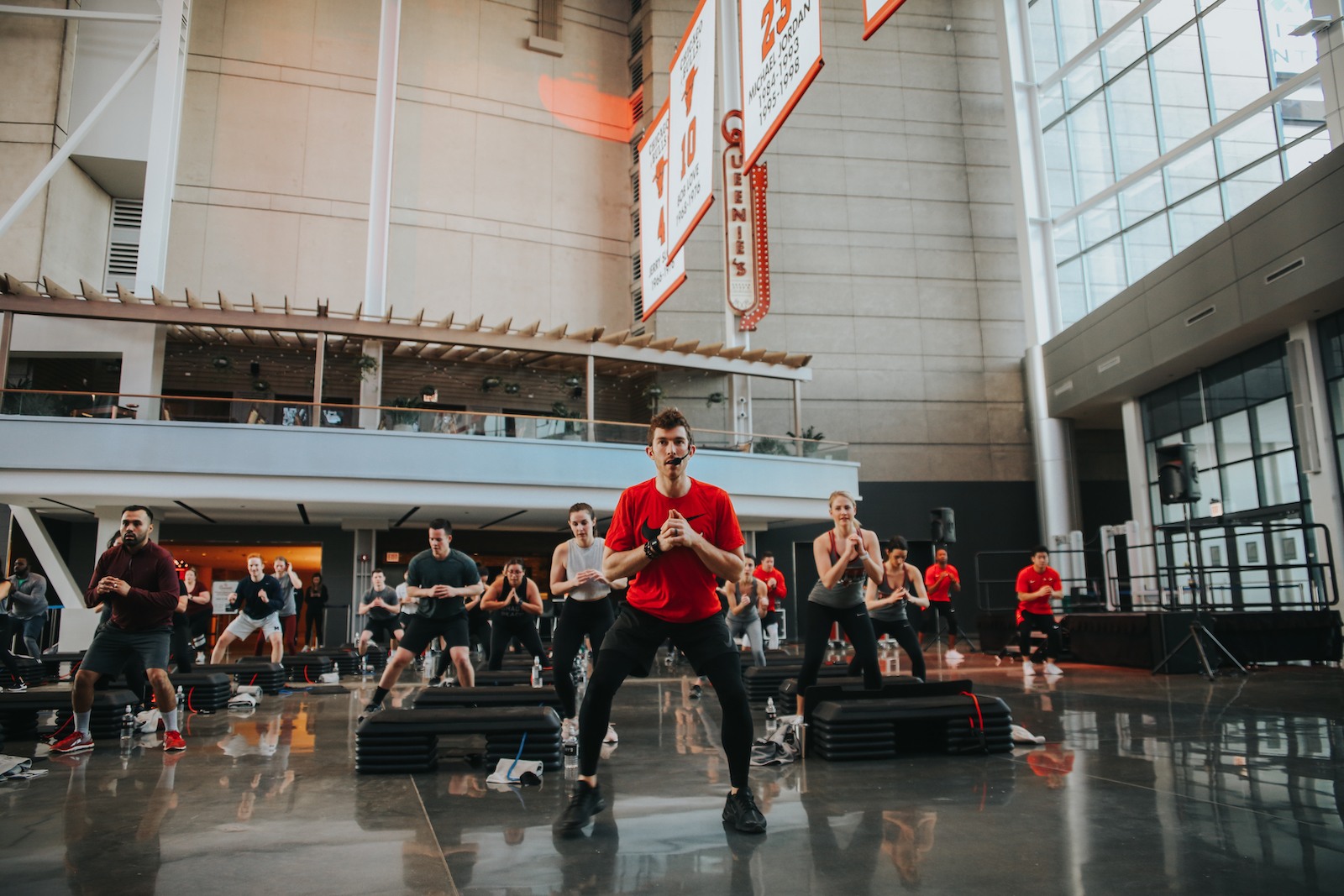 Barry's Bootcamp-instruktør i rød t-shirt førende klasse i United Center Atrium i Chicago