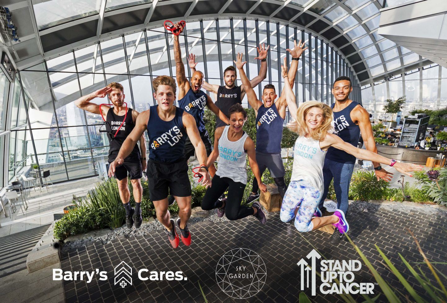 Barry's Bootcamp instructors jumping in London Sky Garden with Barry's Cares, Sky Garden, and Stand up to Cancer logos