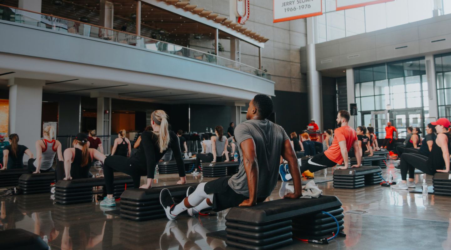 Barry's Bootcamp class in atrium of United Center in Chicago doing tricep dips