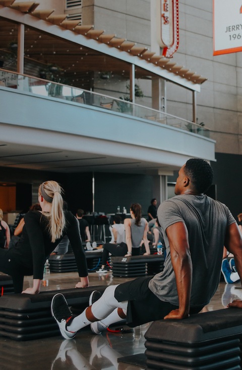 Barry's Bootcamp class in atrium of United Center in Chicago doing tricep dips