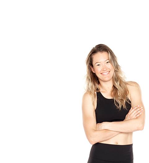 Barry's Bootcamp instructor Georgia Fitzgerald crossing her arms and wearing a black sports bra against a white background.
