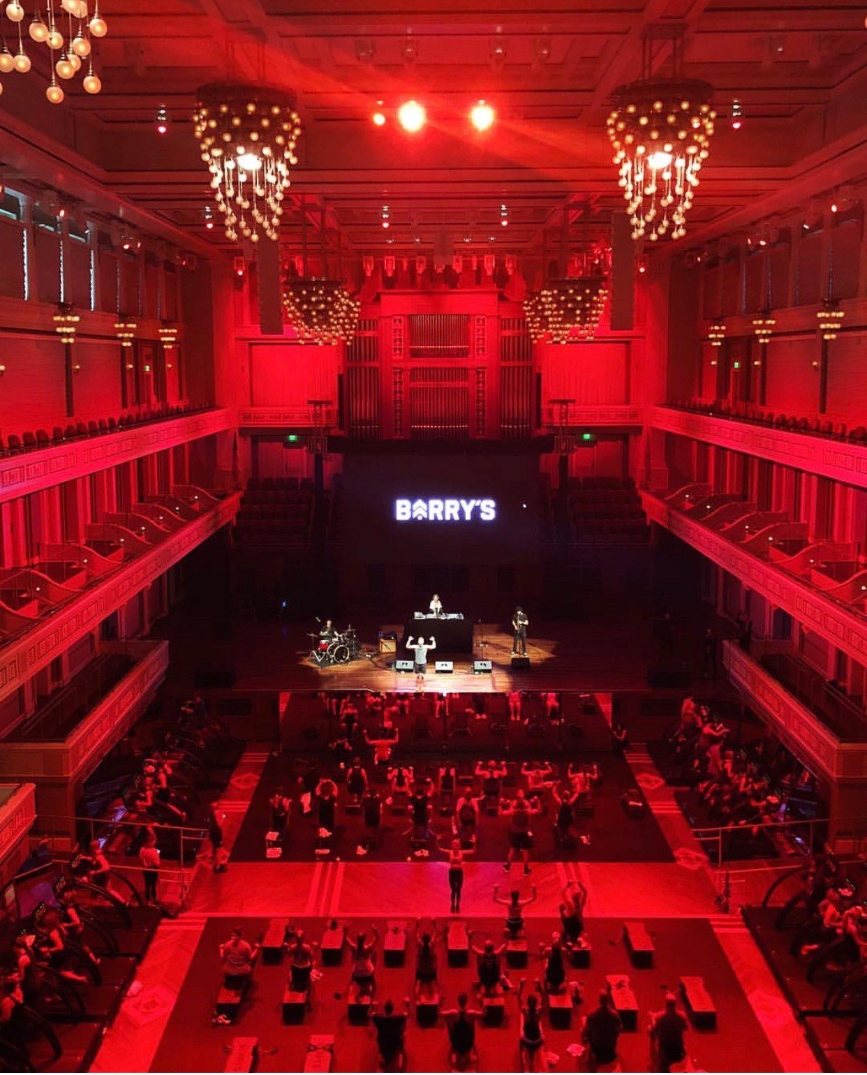 Shermerhorn Symphony Center lit up in red light while Barry's Bootcamp instructors teach a fitness class