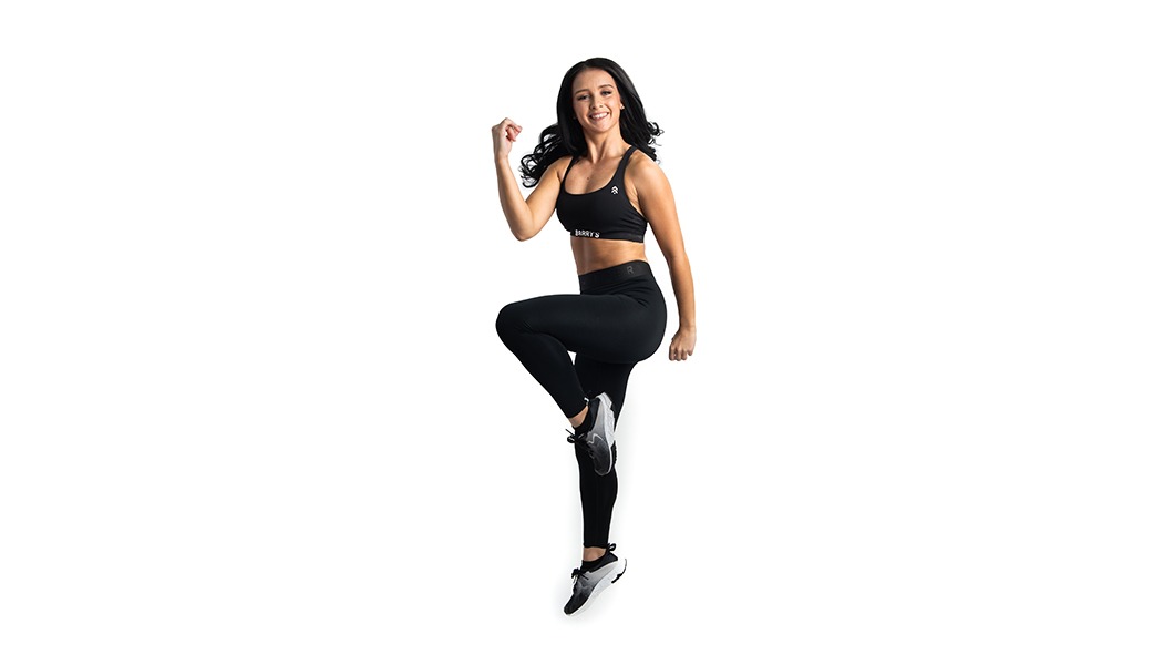 Barry's Bootcamp instructor Lorna Murphy on white background doing high knees exercise move