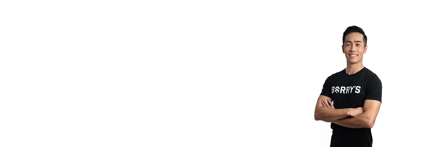 Instructor Jeremy Lee on white background smiling with crossed arms while wearing Barry's Bootcamp t-shirt