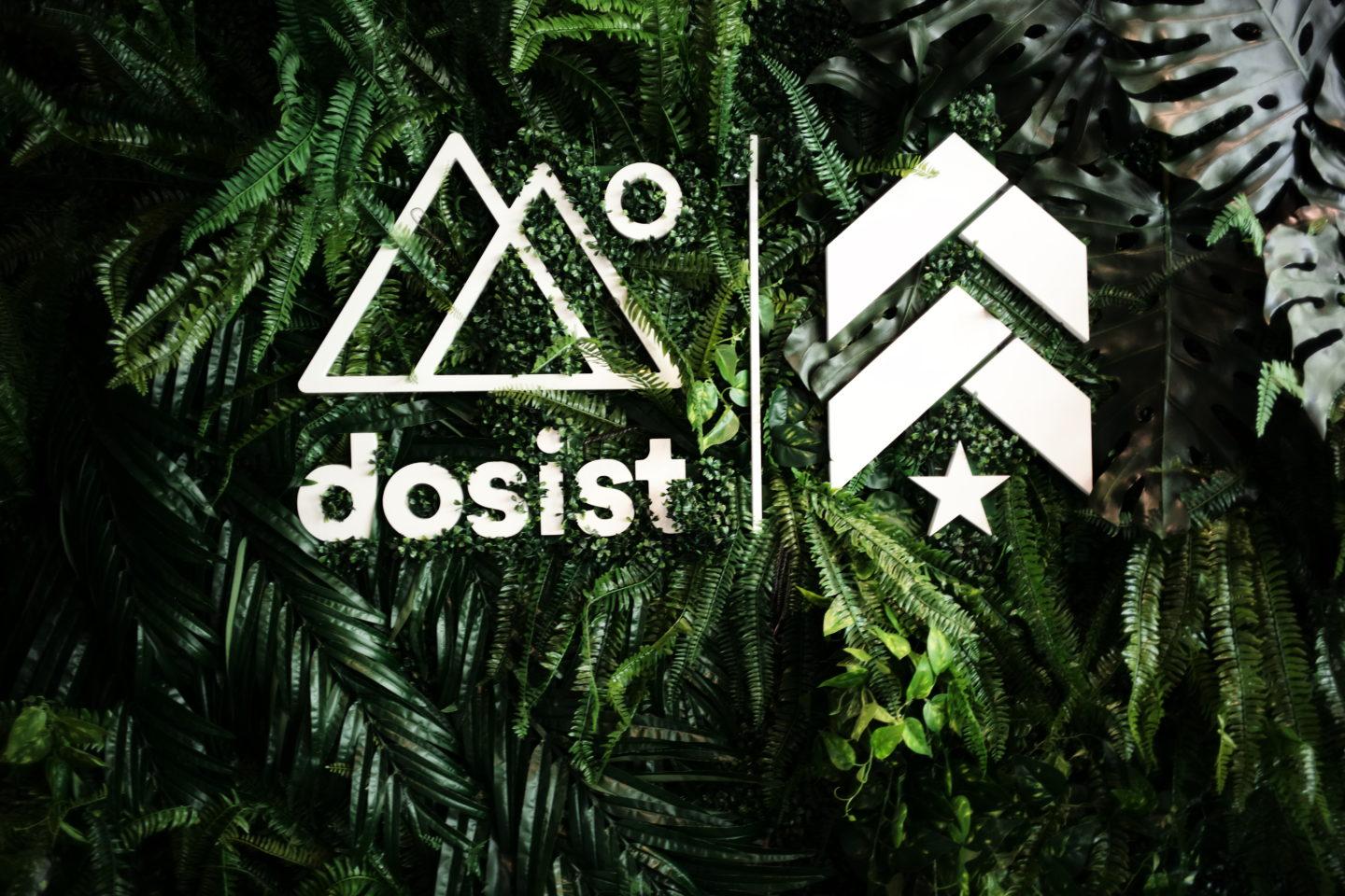 Dosist double triangle and Barry's Bootcamp upward arrows and star logos on wall of greenery
