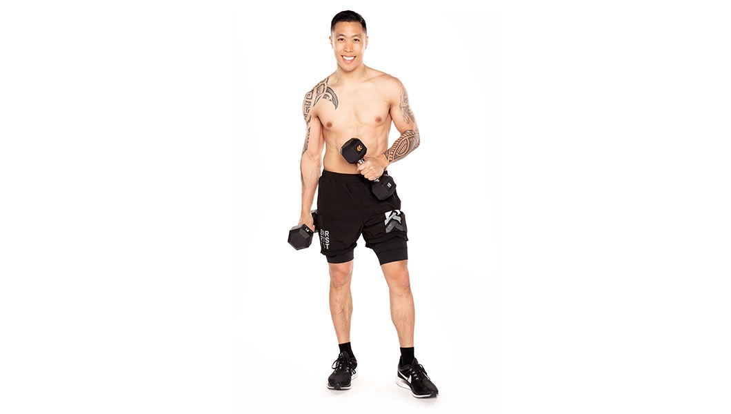 Barrys Bootcamp-instruktör Matt Marquez gör en liten bicepscurl mot en vit bakgrund.