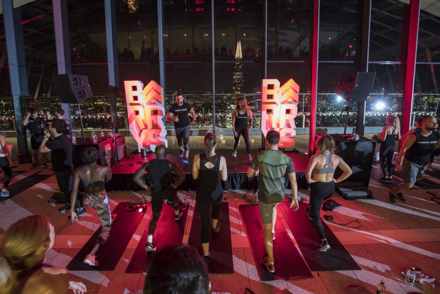 Barry's Bootcamp London Sky Garden participants following instructors doing fitness moves on stage