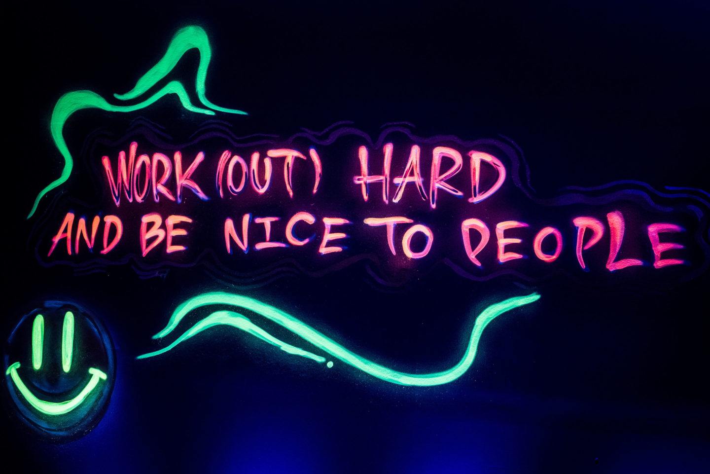 workout out hard and be nice to people written in UV paint glowing in the dark