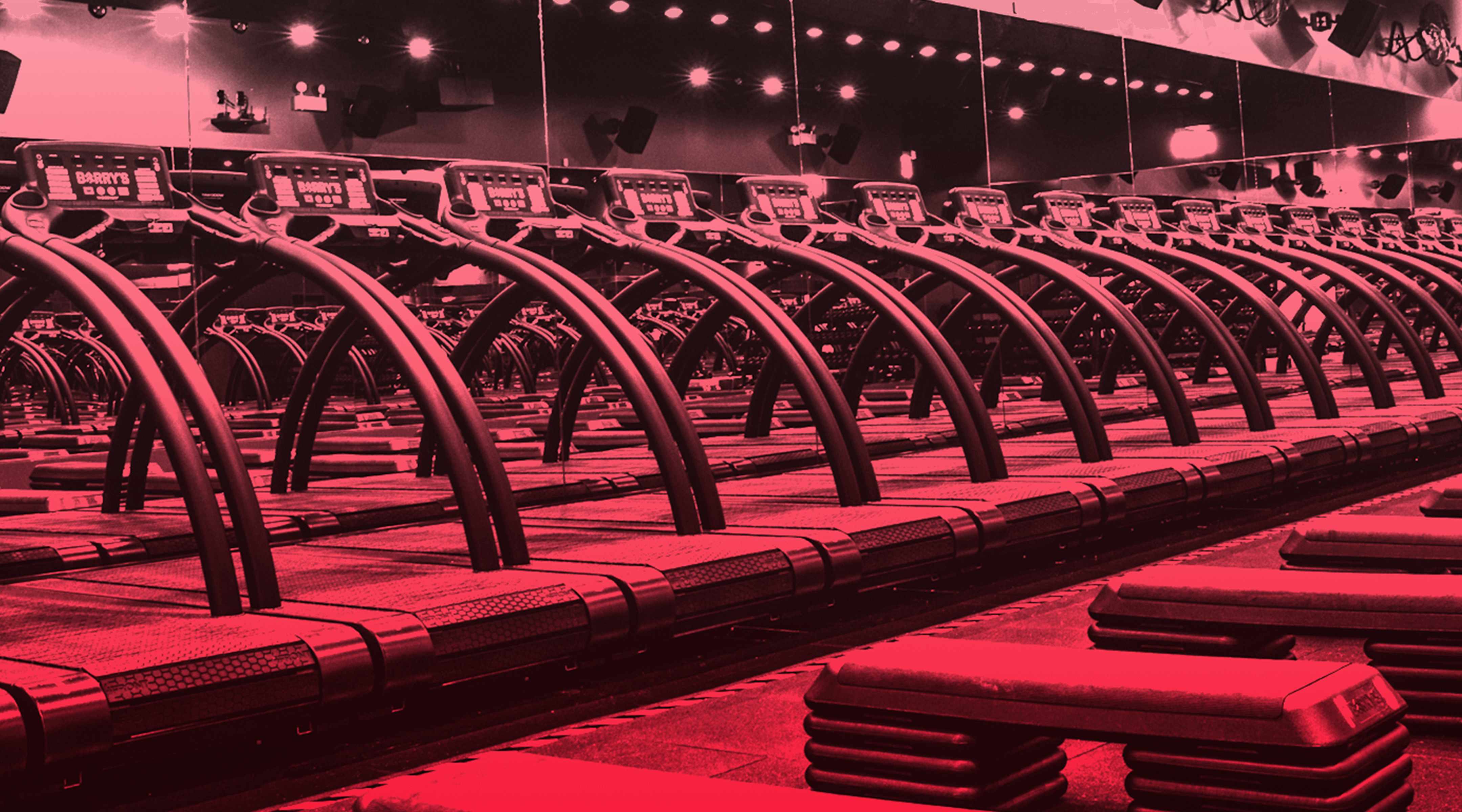 Line of treadmills in front of mirror in Barry's Bootcamp Red Room