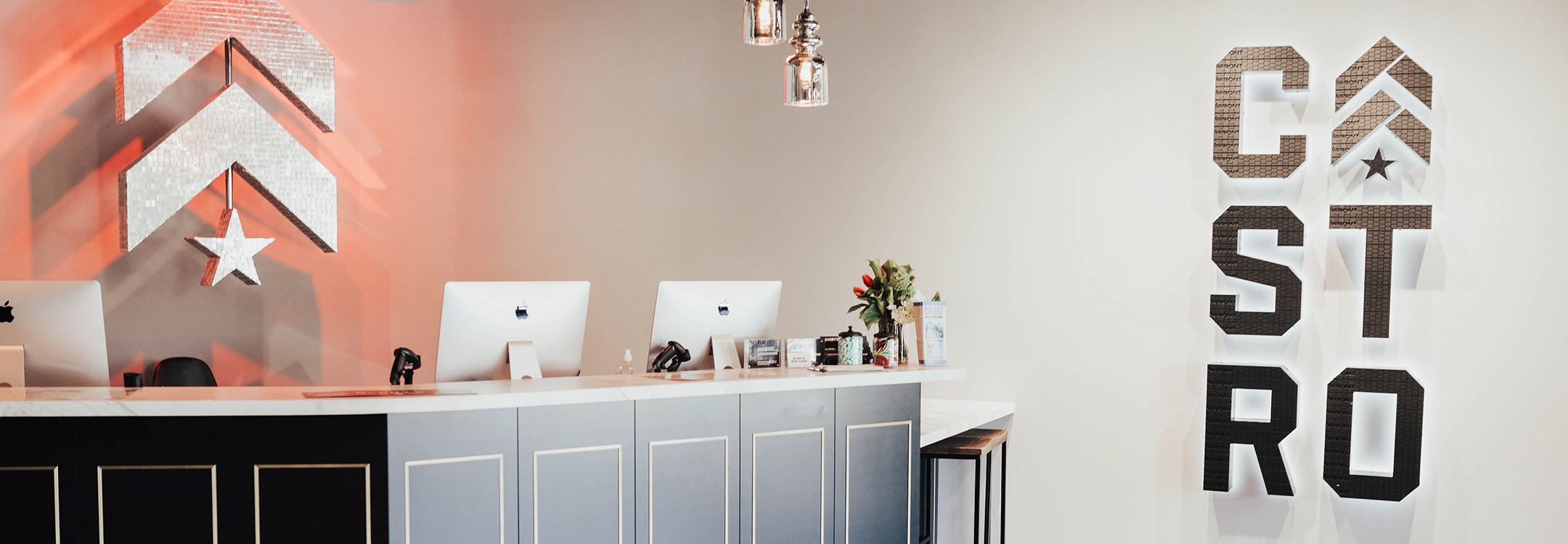 Silver Barry's Bootcamp upward arrows and star logo on wall behind reception area of Castro studio location