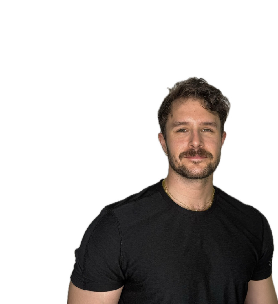 Barry’s instructor wearing a black top standing confidently smiling against a white background