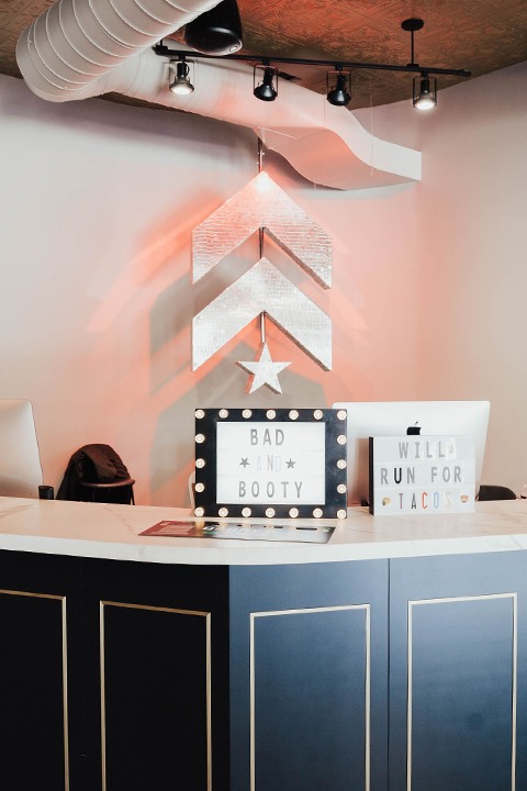 Silver Barry's Bootcamp upward arrows and star logo on wall behind reception area of Castro studio location