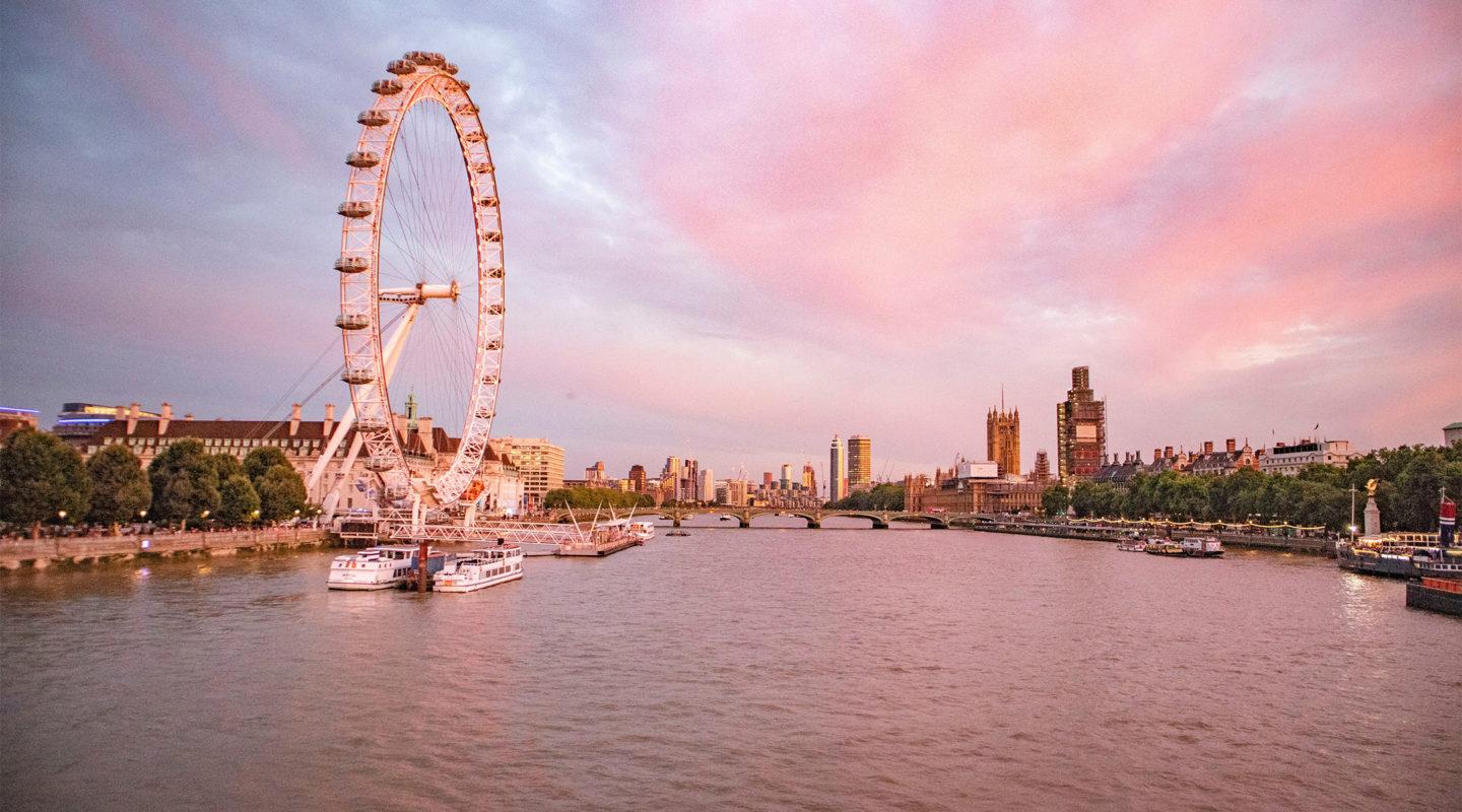 London Eye and the River Thames against a cotton candy sunset sky