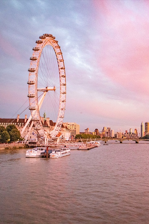 London Eye and the River Thames against a cotton candy sunset sky