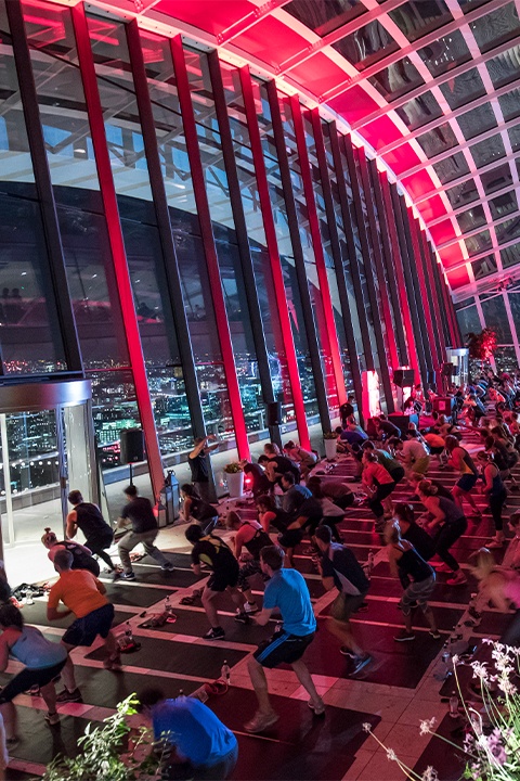Barry's Bootcamp fitness class in London Sky Garden in front of large glass windowed wall