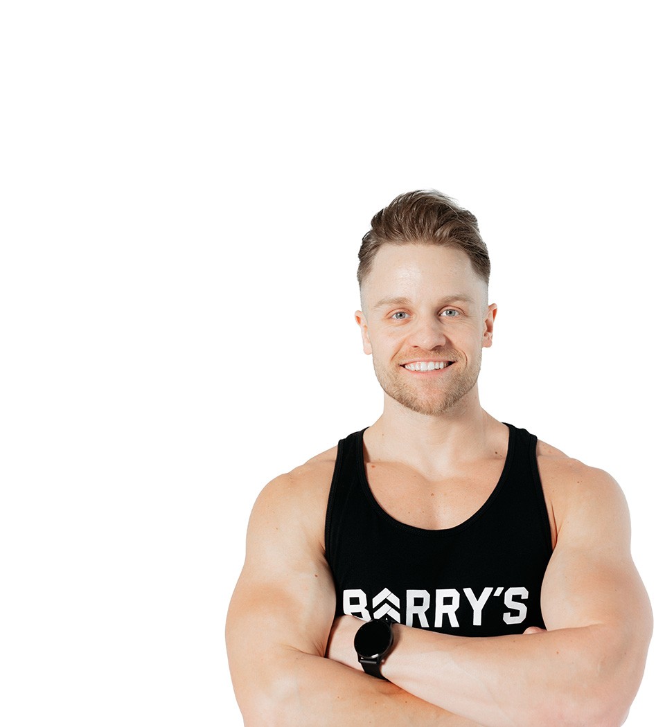 Barrys instruktör iklädd en svart topp står självsäkert och ler mot en vit bakgrund