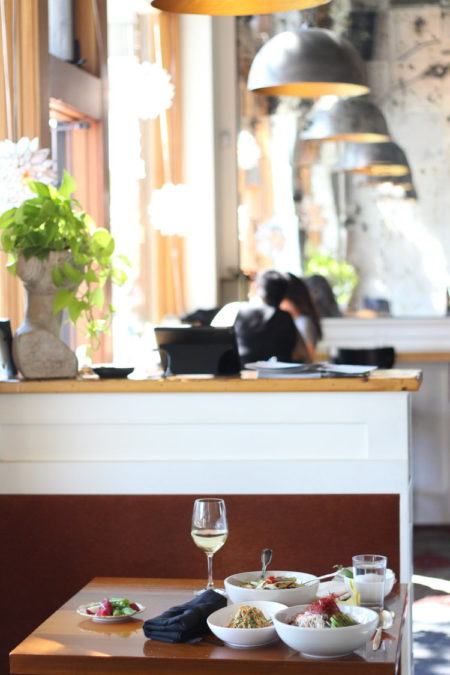 litet fyrkantigt bord för två med mat och dryck på restaurang