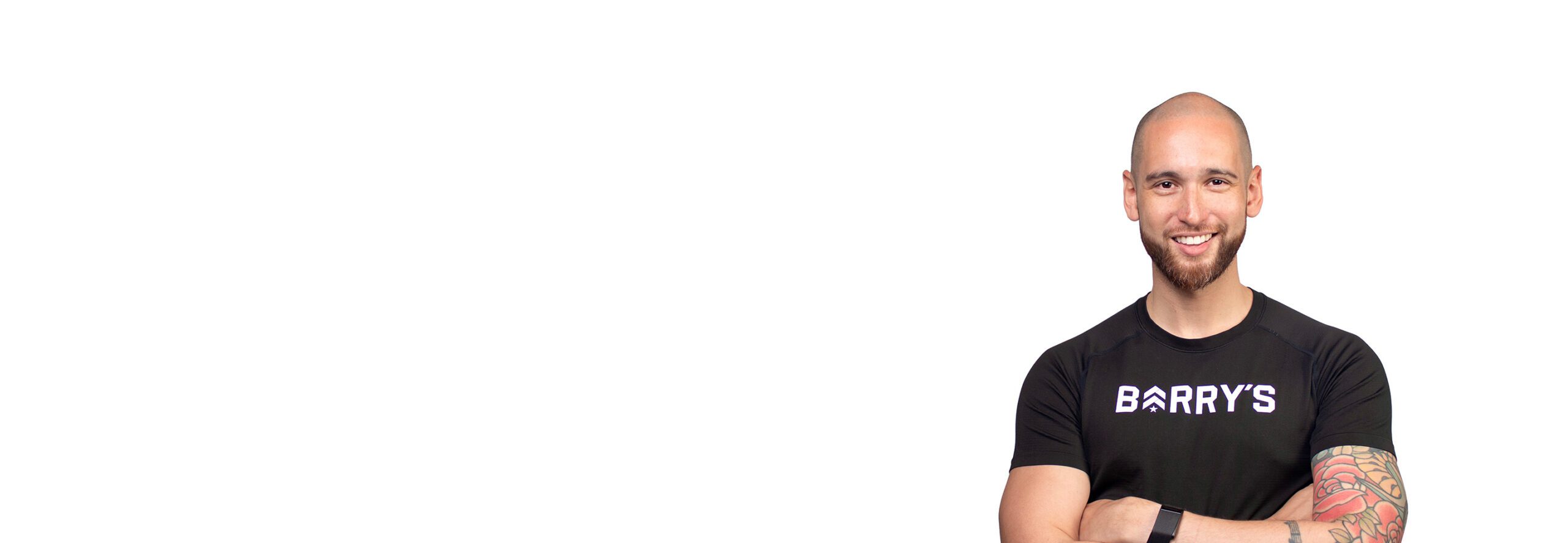 Barrys instruktör iklädd en svart topp står självsäkert och ler mot en vit bakgrund