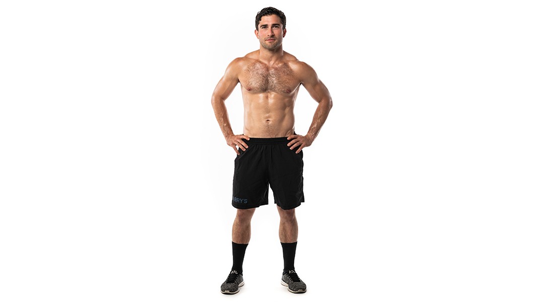 Barry's instructor shirtless standing confidently with hands on hips camera against a white background.