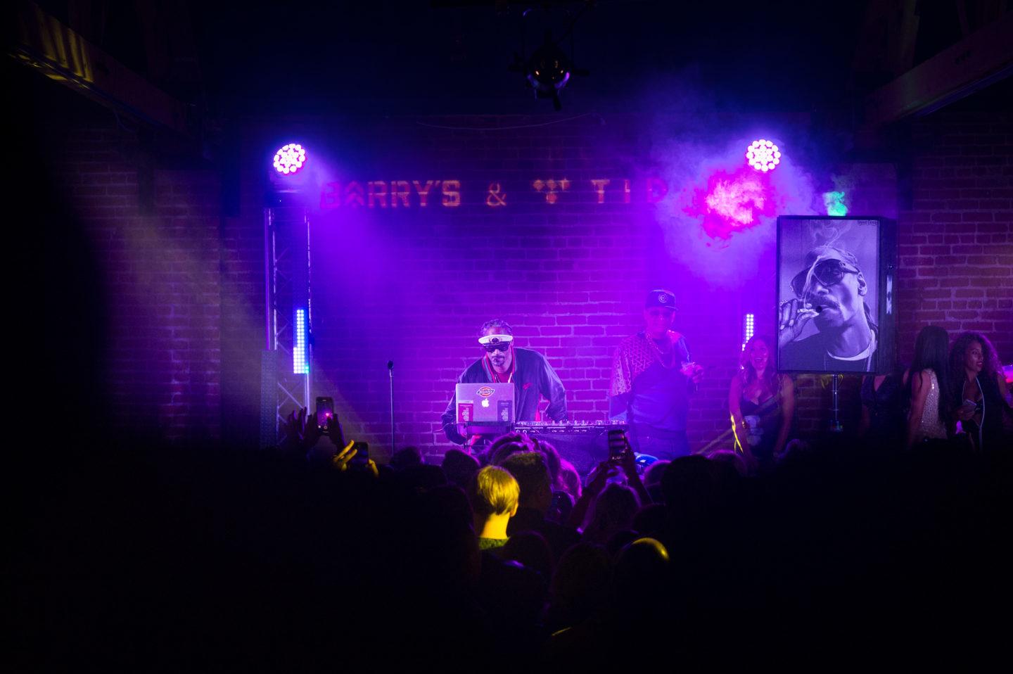 Snoop Dogg using a laptop on stage during his performance