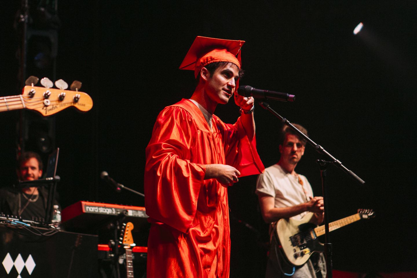 Artista che indossa un cappello e un camice sul palco