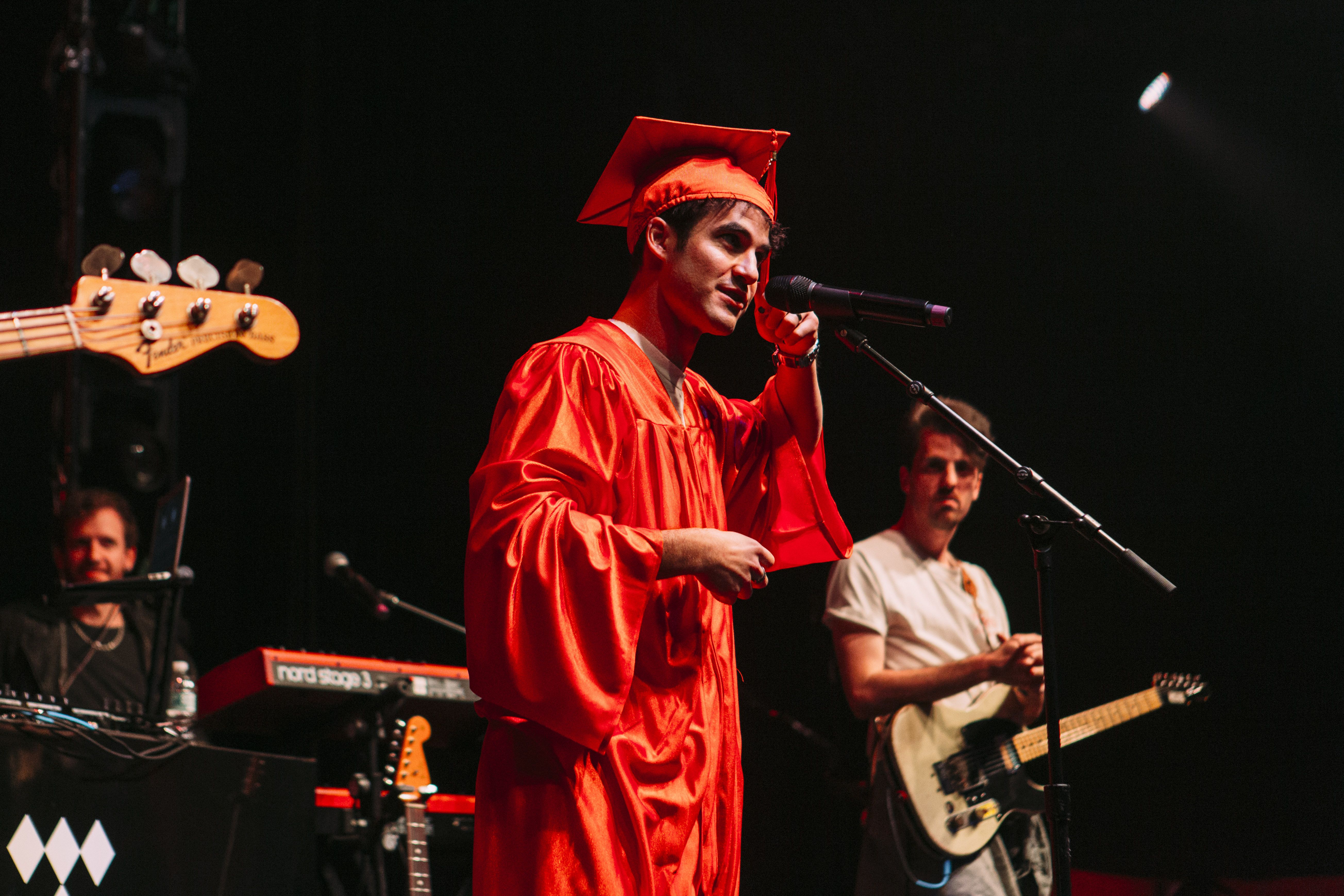 Artist wearing a cap and gown on stage