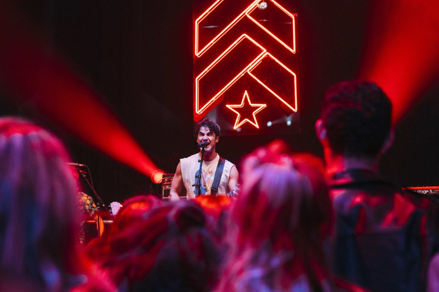 Artist singing and playing guitar on stage