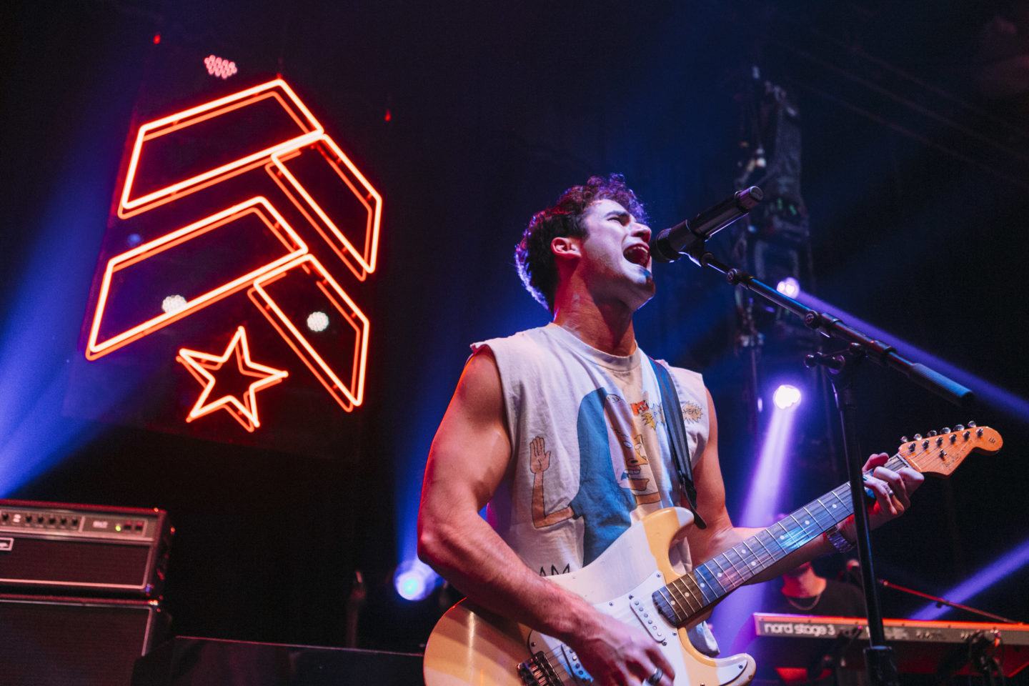 Artist singing and playing guitar on stage