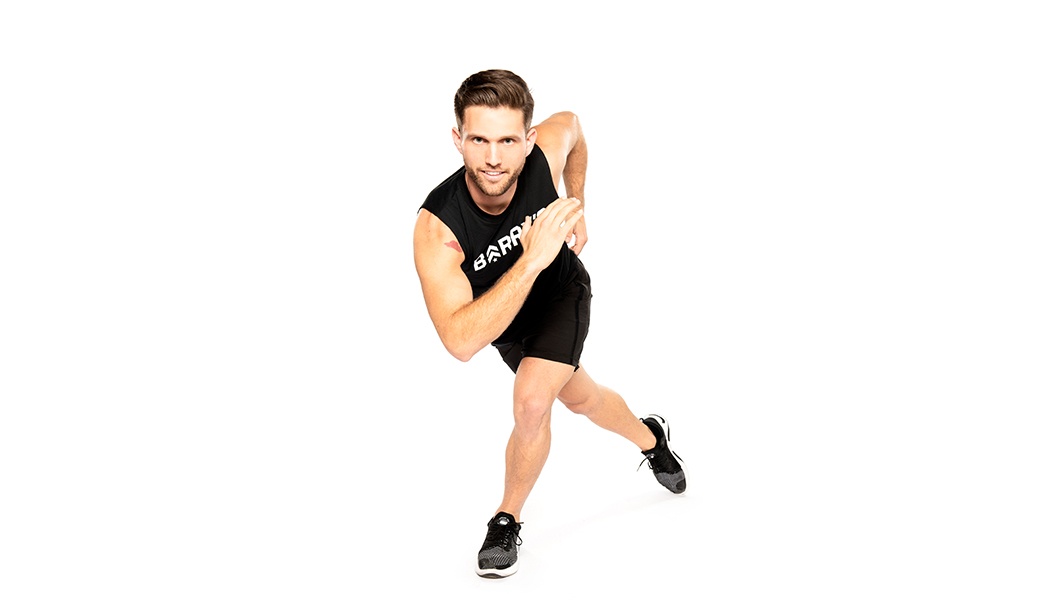 Barry's instructor in running position wearing a black top against a white background.