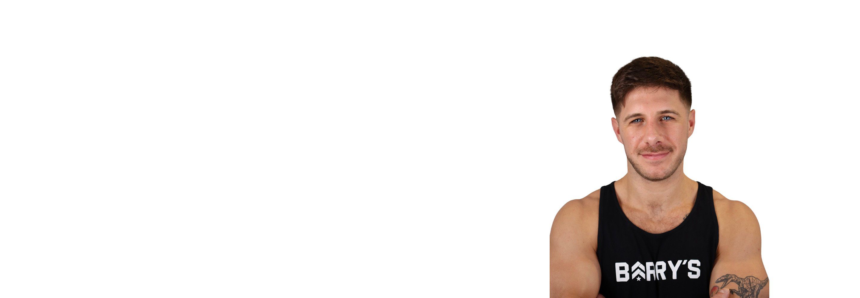 Barry’s instructor wearing a black top standing confidently smiling against a white background