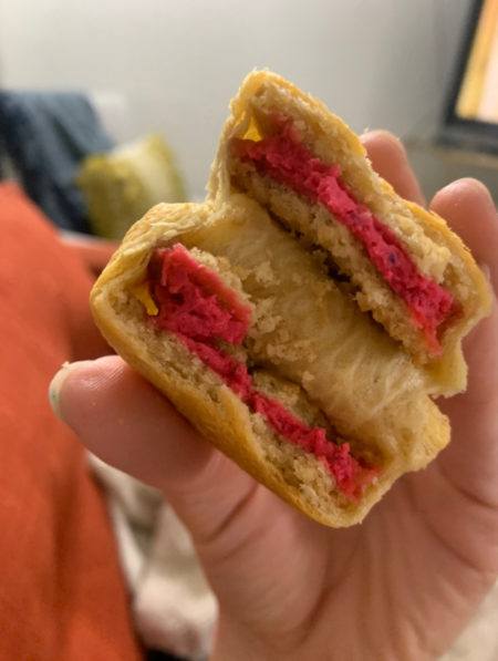 Un Golden Oreo fritto all'aria, con glassa rosa, avvolto in un croissant