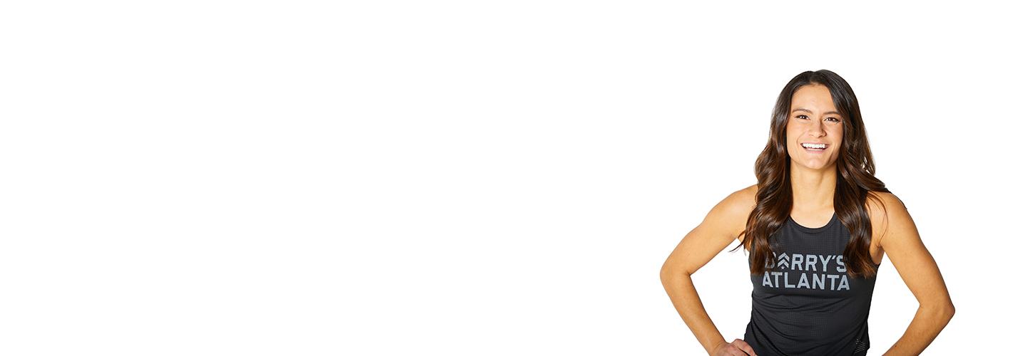 Barrys instruktör står självsäkert klädd i en svart topp mot en vit bakgrund.