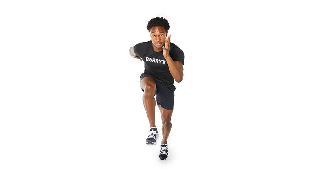 Barry’s instructor wearing a black top in a runners lunge against a white background