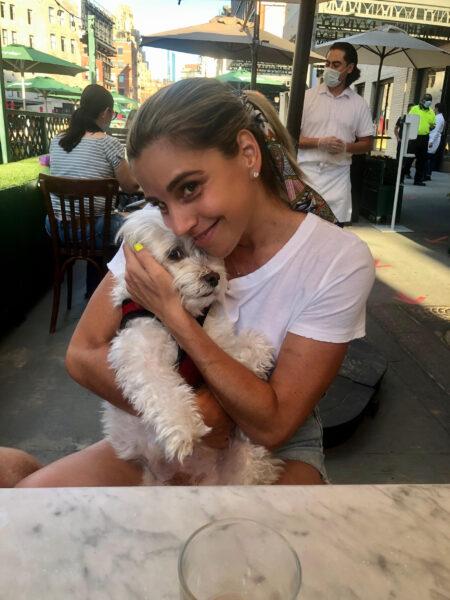 Instructora sénior, Alycia Stevenin, sosteniendo a su perro en un restaurante